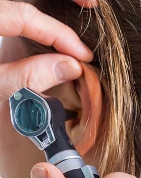 Doctor looking into patients ear
